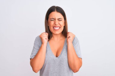 İzole edilmiş beyaz arka planda duran güzel genç bir kadının portresi. Başarı için heyecanlı kolları havada ve gözleri kapalı zaferi kutlarken gülümsüyor. Kazanan konsept.