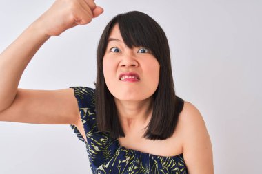 Yazlık çiçekli tişört giyen genç, güzel Çinli bir kadın. İzole edilmiş beyaz arka plan üzerinde. Öfkeyle bağırıyor, çıldırıyor ve öfkeyle bağırıyor.