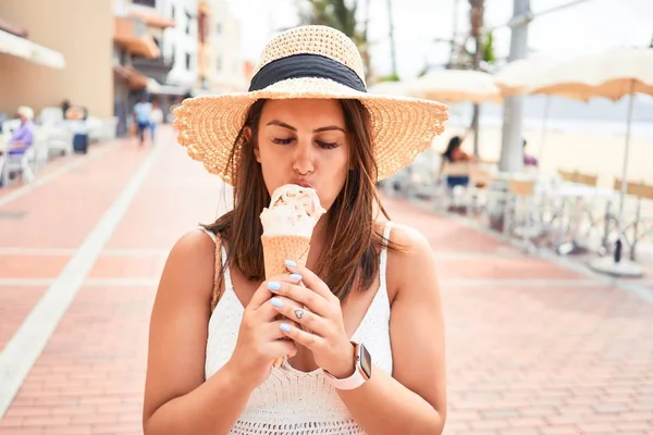 夏の晴れた日の休日にビーチでアイスクリームコーンを食べる若い美しい女性 — ストック写真