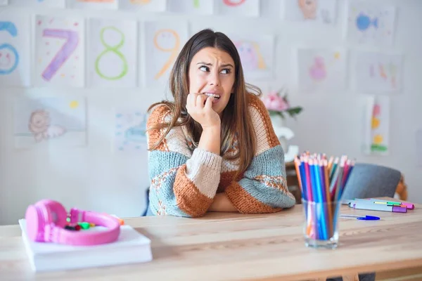 Młoda Piękna Nauczycielka Nosząca Sweter Okulary Siedząca Biurku Przedszkolu Wyglądająca — Zdjęcie stockowe