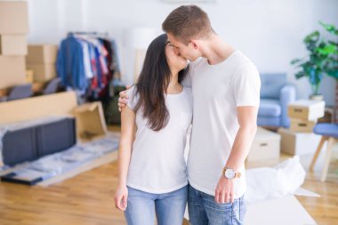 Karton kutuların etrafında duran genç ve güzel bir çift.