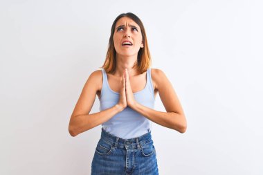 Güzel kızıl saçlı kadın izole edilmiş arka planda duruyor. Elleriyle yalvarıyor ve dua ediyor. Yüzünde umut ifadesi var. Af diliyor. Din kavramı.