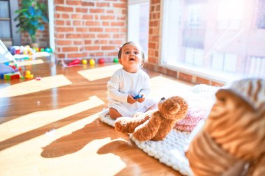 Anaokulunda renkli oyuncaklar arasında mutlu güzel bir bebek.