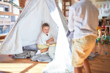 Anaokulunda bir sürü oyuncakla oynayan sevimli sarışın ikizler.