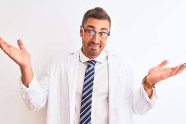 Genç, yakışıklı terapist, soyutlanmış arka planda bilgisiz ve kafası karışmış, elleri ve kolları havada. Şüphe kavramı.