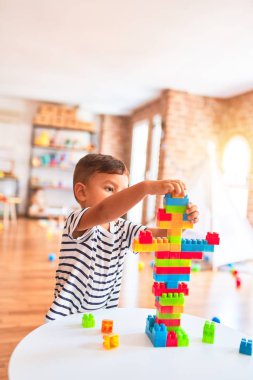 Güzel çocuk anaokulunda inşaat bloklarıyla oynuyor.