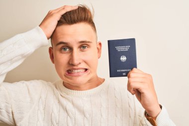 Alman pasaportu taşıyan yakışıklı genç adam, izole edilmiş beyaz bir altyapıya sahip, elleri başının üstünde, utanç ve şaşkınlık dolu, sinirli ve hayal kırıklığına uğramış bir halde. Hata için korku ve üzüntü.