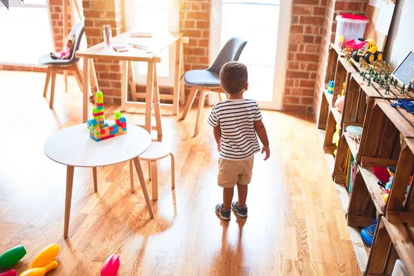 Anaokulunda bir sürü oyuncakla bekleyen güzel bir çocuk.