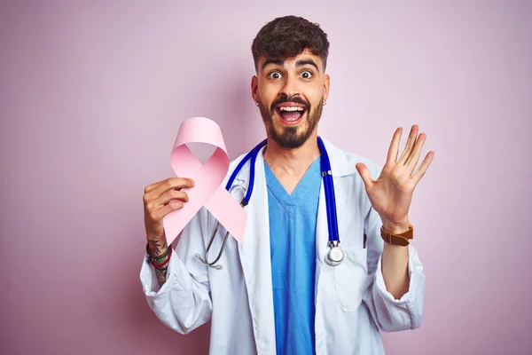 Young Doctor Man Tattoo Holding Cancer Ribbon Standing Isolated Pink — Stock Photo, Image