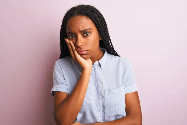 若いですアフリカ系アメリカ人女性を身に着けています縞模様のシャツを身に着けています独立したピンクの背景の上に立って考えて疲れと退屈でうつ病の問題 — ストック写真