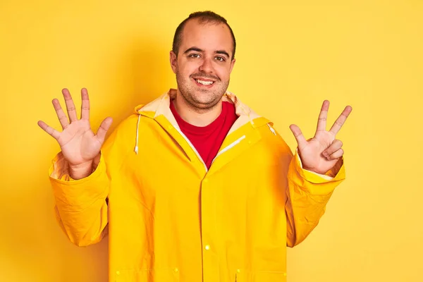 Jovem Vestindo Capa Chuva Sobre Fundo Amarelo Isolado Mostrando Apontando — Fotografia de Stock