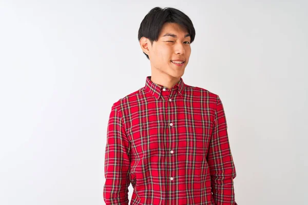 年轻的中国男人穿着宽松的红色衬衫 站在孤独的白色背景上眨着眼睛 带着性感的表情 笑容满面地看着相机 — 图库照片