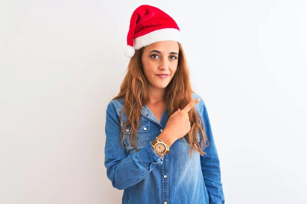 Jonge Mooie Roodharige Vrouw Dragen Kerstmuts Geïsoleerde Achtergrond Wijzend Met — Stockfoto