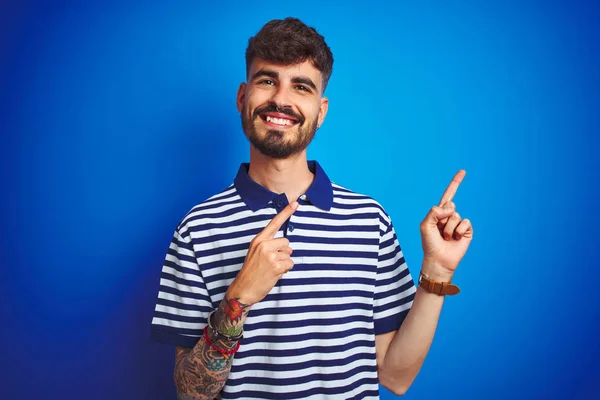 Jovem Com Tatuagem Vestindo Pólo Listrado Sobre Fundo Azul Isolado — Fotografia de Stock