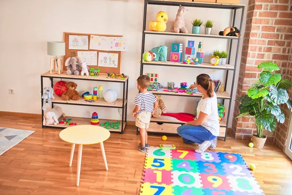 Schöne Lehrerin Und Kleinkind Sitzen Auf Puzzle Spielen Mit Zahlen — Stockfoto