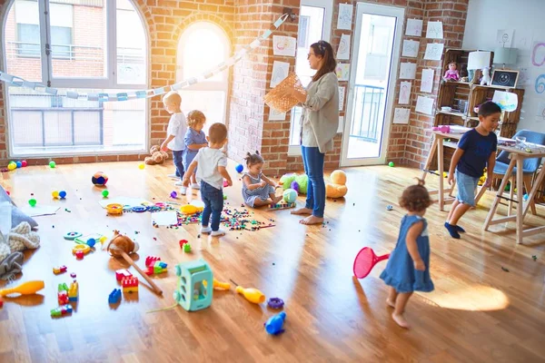 漂亮的老师和一群幼儿在幼儿园玩很多玩具 — 图库照片