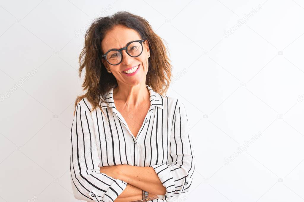 Middle age businesswoman wearing striped dress and glasses over isolated white background happy face smiling with crossed arms looking at the camera. Positive person.
