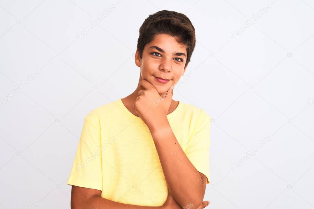 Handsome teenager boy standing over white isolated background looking confident at the camera smiling with crossed arms and hand raised on chin. Thinking positive.