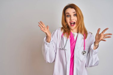 Pembe steteskop takan kızıl saçlı doktor kadın çılgın ve başarıyı kollarını kaldırıp heyecanla haykırarak kutluyor. Kazanan konsept