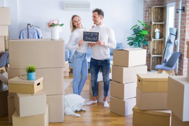 Karton kutuların etrafındaki yeni evlerinde ellerinde karatahtayla bekleyen genç ve güzel bir çift.