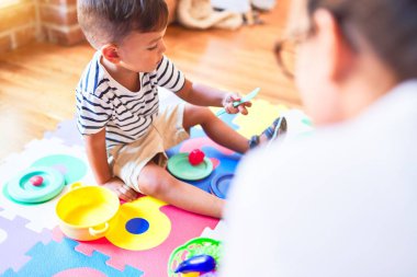 Anaokulunda plastik tabaklar, meyveler ve sebzelerle oynayan güzel çocuk.