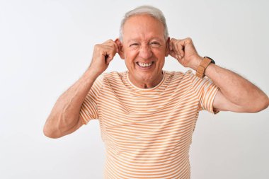 İzole edilmiş beyaz arka planda duran çizgili tişört giyen yaşlı gri saçlı adam parmaklarıyla kulaklarını çekerek gülümsüyor, komik bir jest. Seçme sorunu
