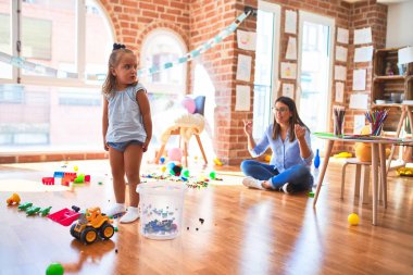 Beyaz kız çocuk, bayan öğretmenle oyun oynayıp öğreniyor. Anne ve kızı oyuncaklarla oyun odasında.