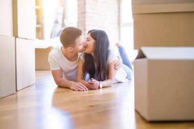 Genç güzel çift karton kutular etrafında yeni evde yatarken