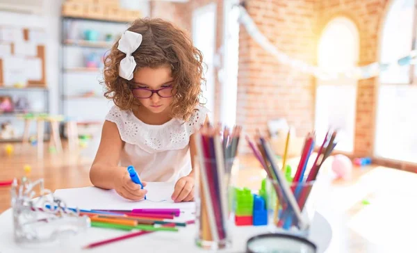 幼稚园中戴眼镜的漂亮幼儿 带着纸笔坐着画画 — 图库照片