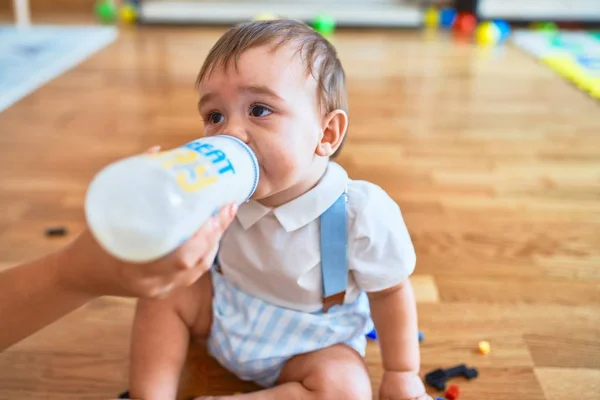 Criança Adorável Sentado Chão Bebendo Leite Usando Garrafa Alimentação Jardim — Fotografia de Stock