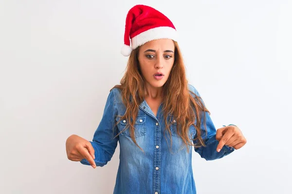 Jonge Mooie Roodharige Vrouw Draagt Kerst Hoed Geïsoleerde Achtergrond Wijzend — Stockfoto