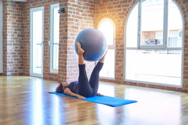 中年漂亮的女运动员在健身房的瑜伽课上用健身球做运动 — 图库照片
