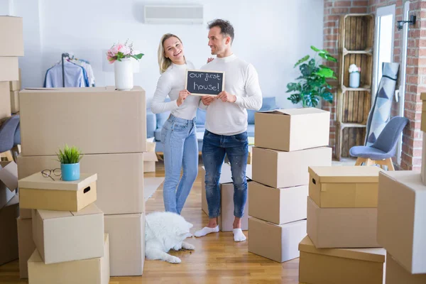 Karton kutuların etrafındaki yeni evlerinde ellerinde karatahtayla bekleyen genç ve güzel bir çift.
