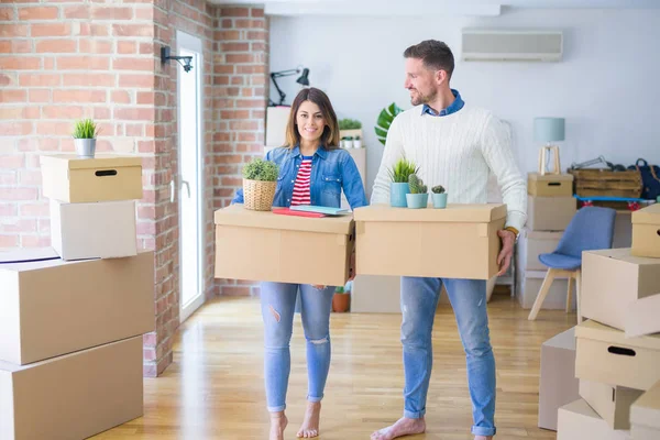 Karton kutuların etrafında genç ve güzel bir çift.