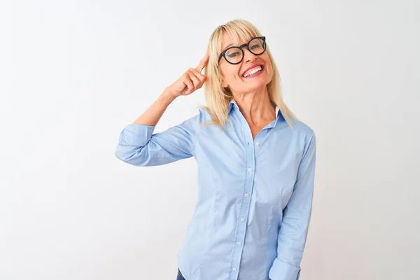中年女商人 身穿雅致的衬衫 戴着眼镜 头戴白色的独立背景 微笑着 用一个手指指着头 很好的主意或想法 好的记忆力 — 图库照片