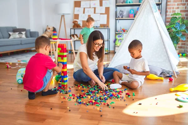 Young Beautiful Teacher Toddlers Playing Building Blocks Lots Toys Kindergarten — Stock Photo, Image