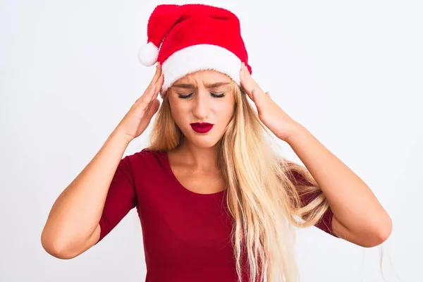 ストレスのために頭の痛みのために頭の上に手で隔離された白い背景にクリスマスのサンタの帽子を身に着けている若い美しい女性 片頭痛に苦しむ — ストック写真
