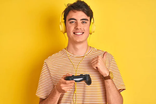 Teenager Αγόρι Παίζει Βιντεοπαιχνίδια Χρησιμοποιώντας Gamepad Πάνω Από Απομονωμένο Κίτρινο — Φωτογραφία Αρχείου