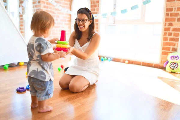 Beautiful Teacher Toddler Building Pyramid Using Hoops Lots Toys Kindergarten — Stock Photo, Image