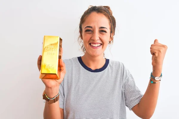 Güzel, kızıl saçlı, altın külçeli genç bir kadın izole edilmiş arka planda gururla bağırıyor, zafer ve başarıyı kutluyor çok heyecanlı, coşkulu bir duygu.