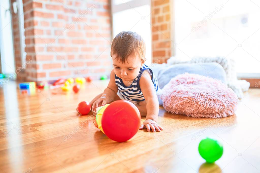 Adorable toddler playing around lots of toys at kindergarten