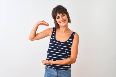 İzole edilmiş beyaz arka plan üzerinde duran çizgili tişört giyen genç ve güzel bir kadın. Ellerinde büyük ve büyük bir işaret, ölçü işareti var. Kameraya bakıp gülümsüyor. Ölçüm konsepti.