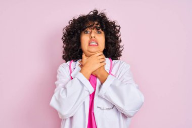 Genç Arap doktor, kıvırcık saçlı, steteskop takan, izole pembe arka planı olan ve boğularak ölen bir kadın. Sağlık problemi. Boğulma ve intihar konsepti.