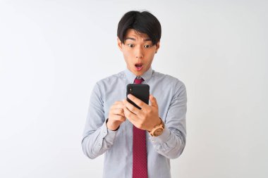 Çinli iş adamı kravat takıyor. Akıllı telefon kullanıyor. İzole edilmiş beyaz arka plan üzerinde duruyor.