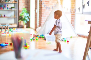 Anaokulunda renkli küçük toplarla oynayan güzel bir çocuk.