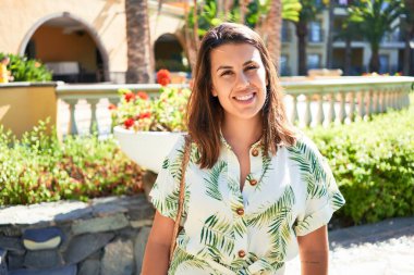 Genç, güzel bir kadın gülümsüyor. Mutlu, güneşli bir yaz gününün tadını çıkarıyor.