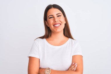 Güzel ve genç esmer bir kadının portresi izole edilmiş beyaz arka planda durmuş kollarını kavuşturup kameraya bakarken gülümseyen mutlu yüz. Pozitif kişi.