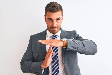 Takım elbiseli ve kravatlı genç yakışıklı bir iş adamı. El kol hareketleri yapıyor, hayal kırıklığına uğramış ve ciddi bir yüz ifadesi takınıyor.