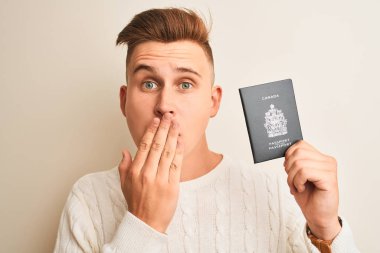 Kanada pasaportu taşıyan yakışıklı genç bir adam izole edilmiş beyaz arka plan üstü ağzı ile kaplıdır. Hata yaptığı için utanır, korkunun dışavurumu, sessizlikten korkar, gizli konsept