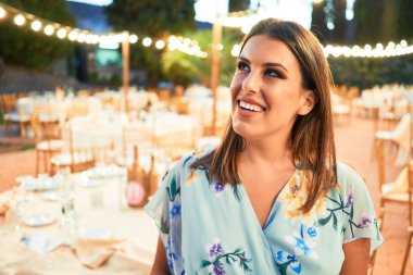 Parti şöleninde mutlu ve neşeli gülümseyen gelinlikli güzel ve zarif bir kadın.